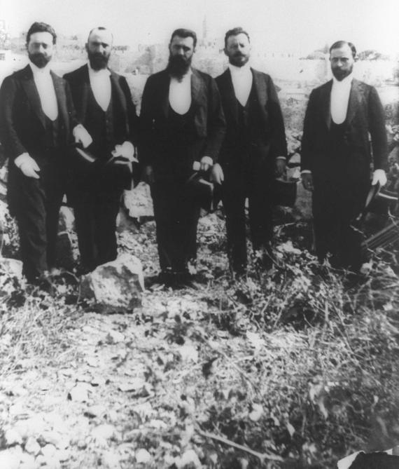 Old photo of five men in suit side by side.