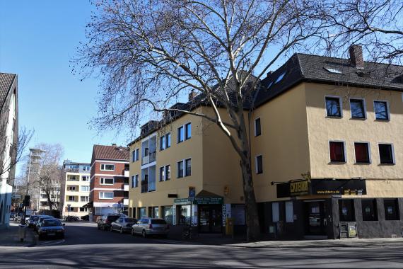 Street with residential buildings and cars.