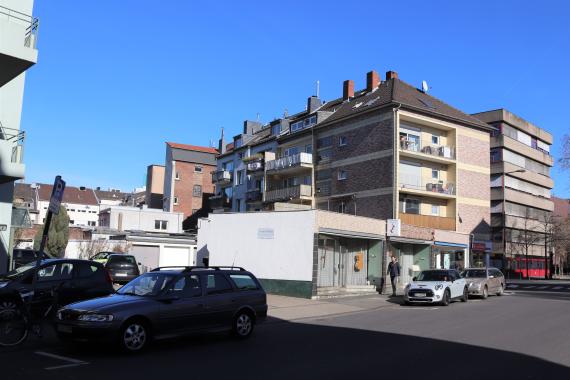 Street with residential buildings and cars.