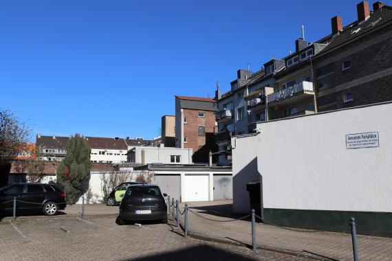 Foto einer Straße mit Auto und Wohngebäuden.