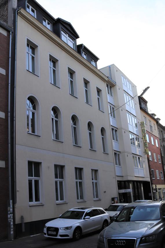 Street with residential buildings and cars.