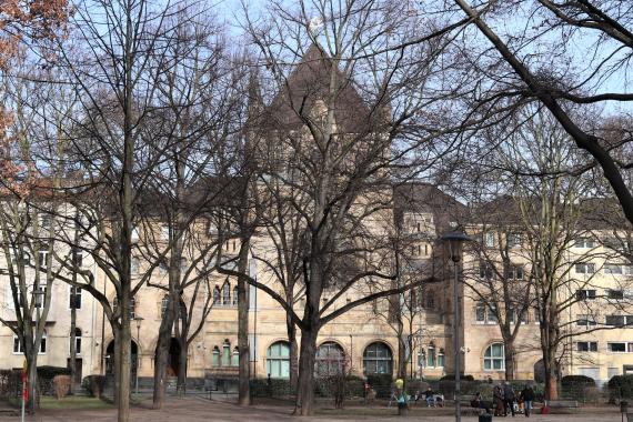 Front view of the synagogue. In the foreground are bare trees.