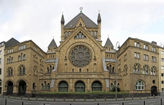 Large synagogue with many windows and David star on the roof.