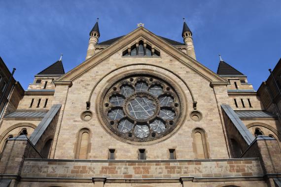 Nahaufnahme der Synagoge aus der Froschperspektive. Großes blumenförmiges Fenster.