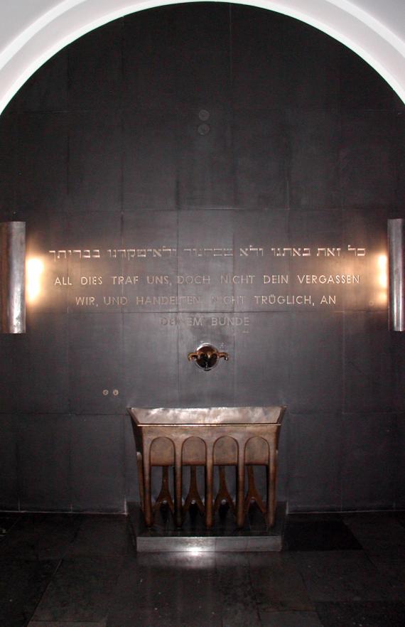 Photo of a sink. Above the sink is an inscription on the wall.