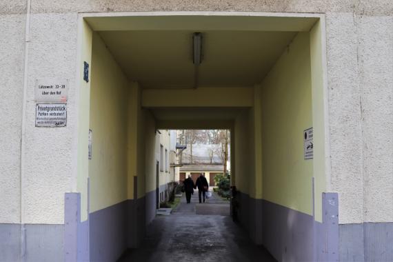 Kleiner Tunnel eines Gebäudes, der zum Innenhof führt.