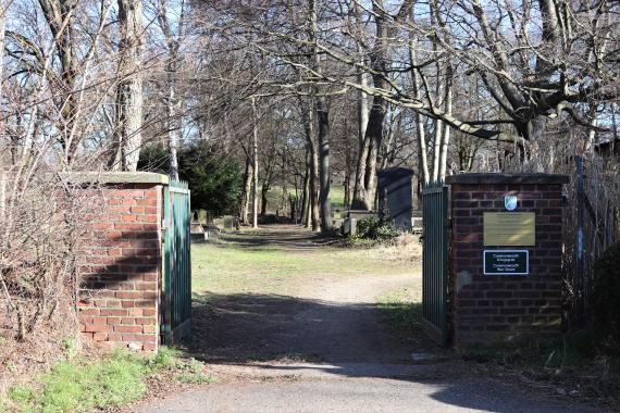 Entrance and wall of the cemetery. In the background are gravestones.