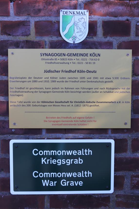 Information sign and coat of arms on the wall of the cemetery.