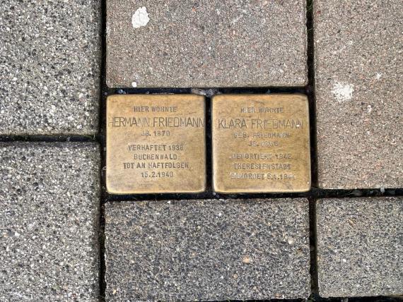 Two stumbling stones of Hermann and Clara Friedmann can be seen in front of the store. The inscription indicates that Hermann Friedmann, born in 1870, was deported to Buchenwald in 1938 and died of the consequences of imprisonment in 1940. Clara Friedmann, born in 1866, was deported to Theresienstadt in 1942 and murdered in 1944.