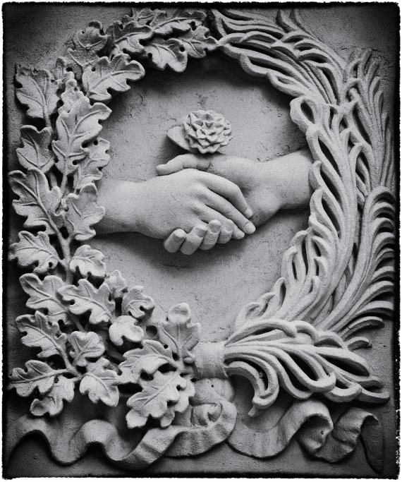 Sandstone relief: Wreath of palm branches and oak leaves, in it two hands with rose in gesture of reconciliation