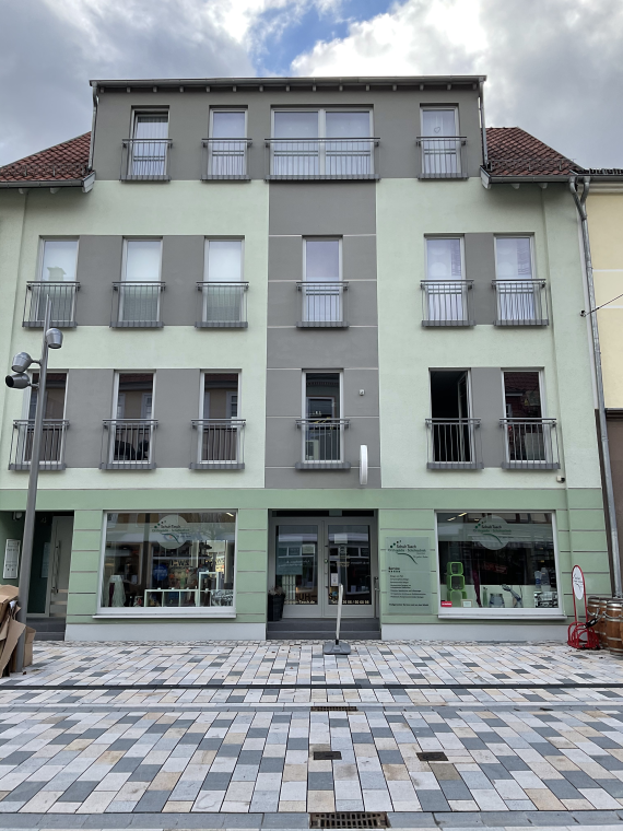 Color photograph of the current four-story building at Wilhelmstraße 4; the basement contains an orthopedic store on the three upper floors apartments