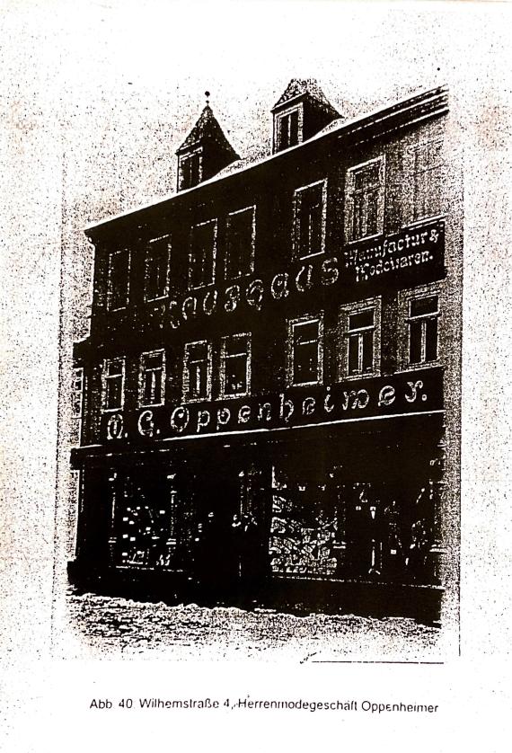 Black and white photograph of a four-story building with the advertising inscription Konfektionshaus M.G. Oppenheimer Manufaktur- und Modewarengeschäft