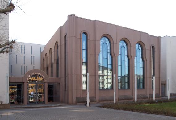 Das Gemeindengebäude mit roter Fassade und riesigen Fenstern