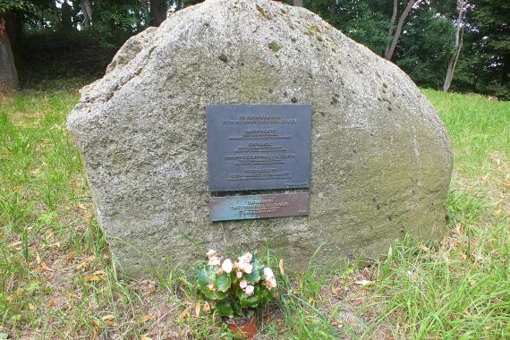 A large gravestone. Metal letters commemorating some Jews who died.