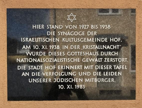 Gedenktafel mit dem Text: "Hier stand von 1927 bis 1938 die Synagoge 
der Israelitischen Kultusgemeinde Hof. Am 10. XI. 1938, in der 'Kristallnacht', wurde dieses Gotteshaus durch nationalsozialistische Gewalt zerstört. Die Stadt Hof erinnert mit dieser 
Tafel an die Verfolgung und die Leiden unserer jüdischen Mitbürger. 
10. XI. 1983."