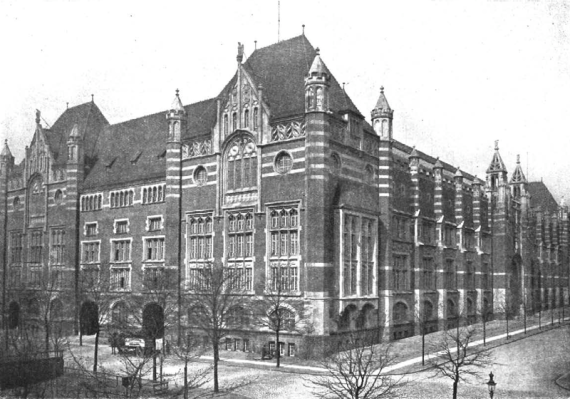 Black and white photo of the telephone exchange Schlüterstraße. Brick building in neo-Gothic style. The main front is symmetrically designed. Four stories plus basement. Three rows of windows. On the fourth floor a large oval window, where there is a round window on the left and right respectively. On the outer edges raised turrets. The roof is pointed. The center of the front of the house with the entrance is set back and much simpler design.