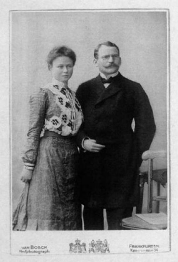 Black and white photograph of Adolf and Johanna Löwenstein, arm in arm in standing position, with signature of photo studio van Bosch below.