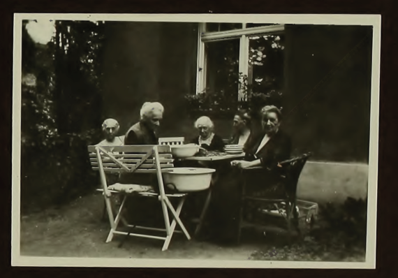 Five residents sit together at the garden table.