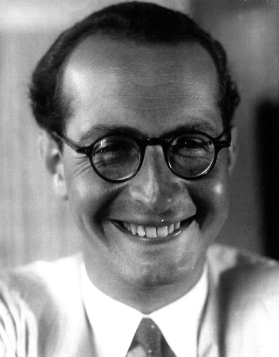 Black and white portrait photograph of Hans Schiff with glasses smiling at camera