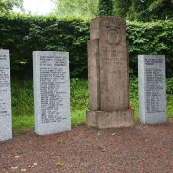 Mehrere hohe Stelen mit eingravierten Namen. Erinnerung an Mitglieder der Gemeinde.