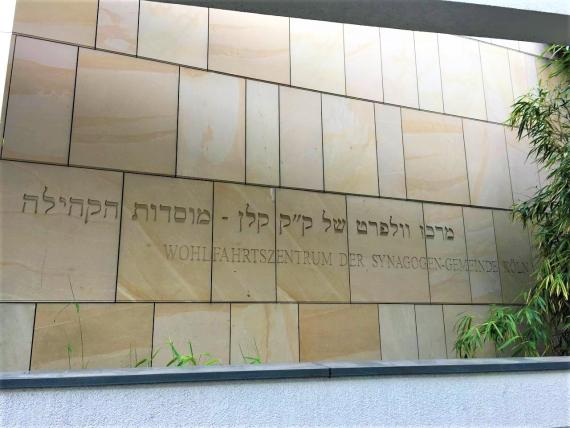 Photograph of the outer wall of the Welfare Center. In Hebrew and German it says: "Wohlfahrtszentrum der Synagogen-Gemeinde Köln".