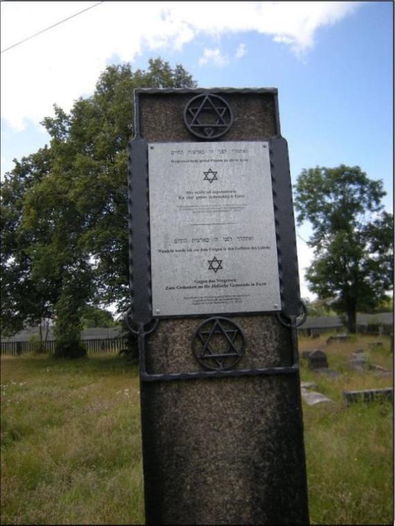 A post with a plaque. Data of the cemetery.