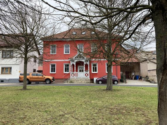 Rotes Gebäude, ehemalige jüdische Schule, davor Rasen mit Bäumen