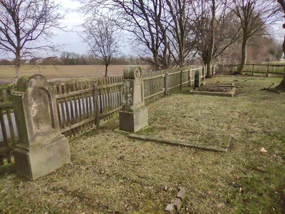 Einige Steine an dem Jägerzaun, der den Friedhof umgibt