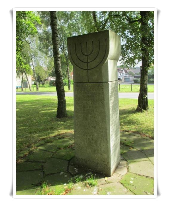 Eine hohe, einzelne Stele. Text erinnert an die Opfer der Shoah.