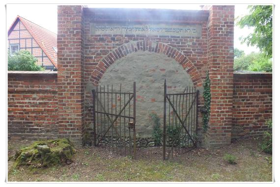 Arched gated gate. Iron wings, stand half open.