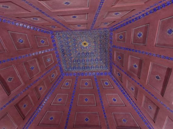 Red, blue and gold colors on a vaulted ceiling, four straight sides running tent-like towards each other, with a gold Star of David at the highest point.