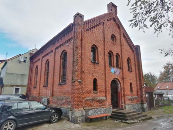 Small house built of red brick, entrance in the middle with four steps in front. A brown sign with the inscription Museum is placed above the door.