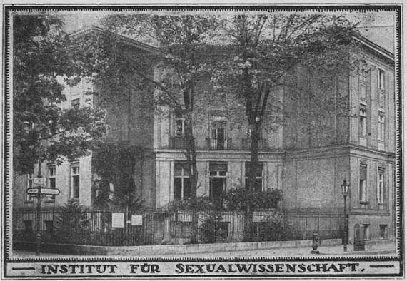 Postkarte mit schwarzem Rand, unten steht: Institut für Sexualwissenschaft. Im Bild zu sehen ist ein städtisches Haus, davor ein Zaun und Bäume.