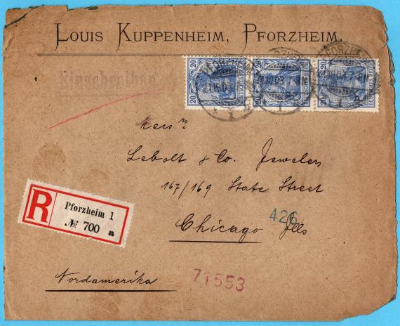 Briefumschlag - Louis Kuppenheim, Pforzheim - versandt am 21. Oktober 1903 nach Chicago. - Im oberen Fünftel des Briefumschlags befindet sich der Name und der Ort des Absenders aufgedruckt. Darunter nach rechts versetzt sind drei blaue miteinander verbundene 20 Pfg Germania-Briefmarken (Rollenmarken), jeweils abgestempelt mit dem Poststempel von Pforzheim, datiert 21.10.1903. Darunter folgt die Anschrift " Lebolt und Co, Jewelers, 167/169 State Street, Chicago. Links davon ist ein Einschreibzettel der Post Pforzheim aufgeklebt- weißer Hintergrund mit rotem Rahmen, einem abgegrenzten großen roten "R"  und daneben in kleinerer Schrift " Pforzheim I - No. 700. - Unter der Einschreibmarke steht noch in Schwarz und unterstrichen " Nordamerika ".