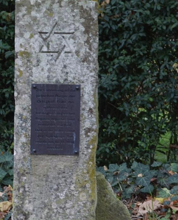 On the photo you can see a stone. A memorial plaque is attached to it. The memorial stone commemorates the Jewish residents of the village who lost their lives at the hands of the Nazis.