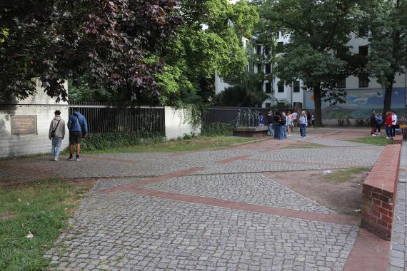 Open space, passers-by and a monument in the background