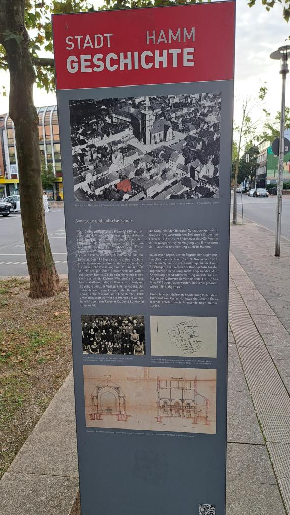 Auf dem Bild ist eine Informationstafel mit Bildern und Text zur jüdischen Geschichte in Hamm zu sehen.