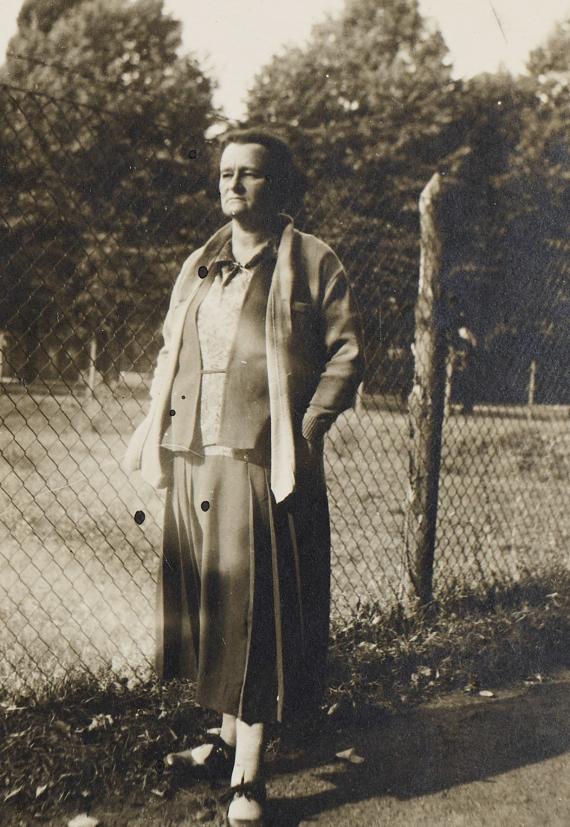 Siddy Wronsky stands in front of a fence