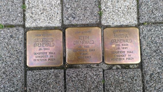 The picture shows the Stumbling Stones for Siegfried, Edith and Martha Grünewald