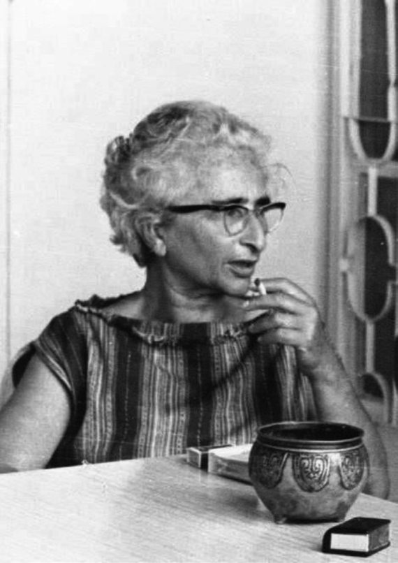 Woman sitting at a table, smoking a cigarette