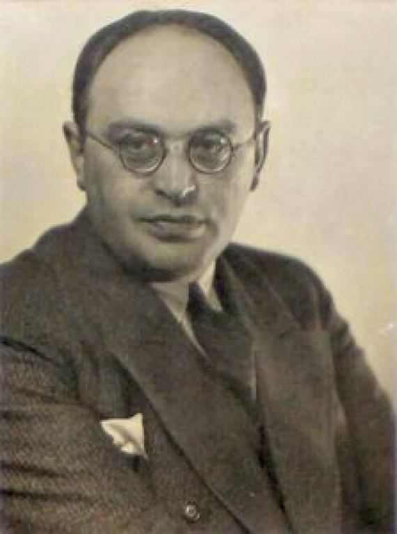 Portrait of a man. He is wearing a suit and glasses. Black and white picture