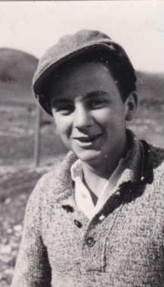 Portrait of a youth with a slouch cap standing outside on a meadow