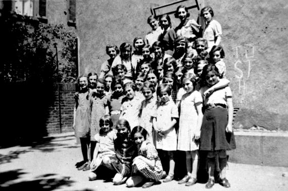 Around 30 girls have gathered in the courtyard of the Israelite Orphanage for a group photo