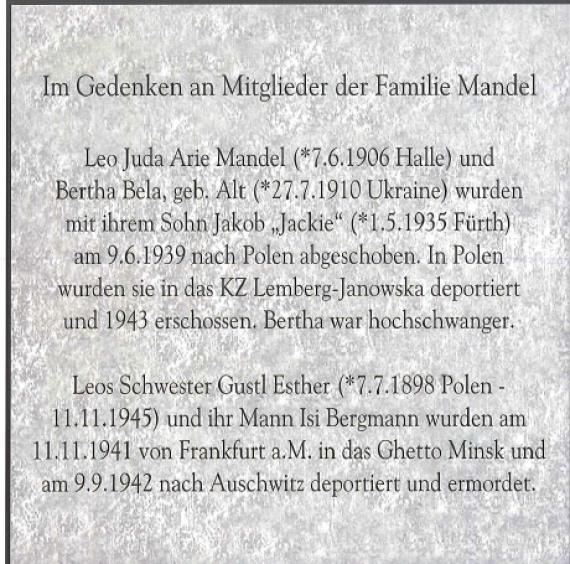 Die Gedenkplatte besteht aus Messing mit eingraviertem Text in Erinnerung an die ermordeten Mitglieder der Familie Mandel, die in der Königswarter Straße 64 wohnten.Die Platte wurde in Königswarter Straße in den Boden eingelassen.