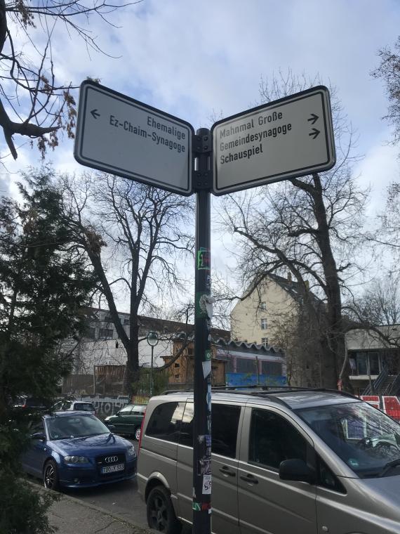 Straßenpfosten mit zwei Wegweisern für Fußgänger, die in unterschiedliche Richtungen deuten