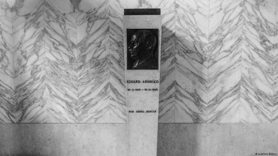 Black and white photograph of a stele with a profile view of a man in front of a marble wall