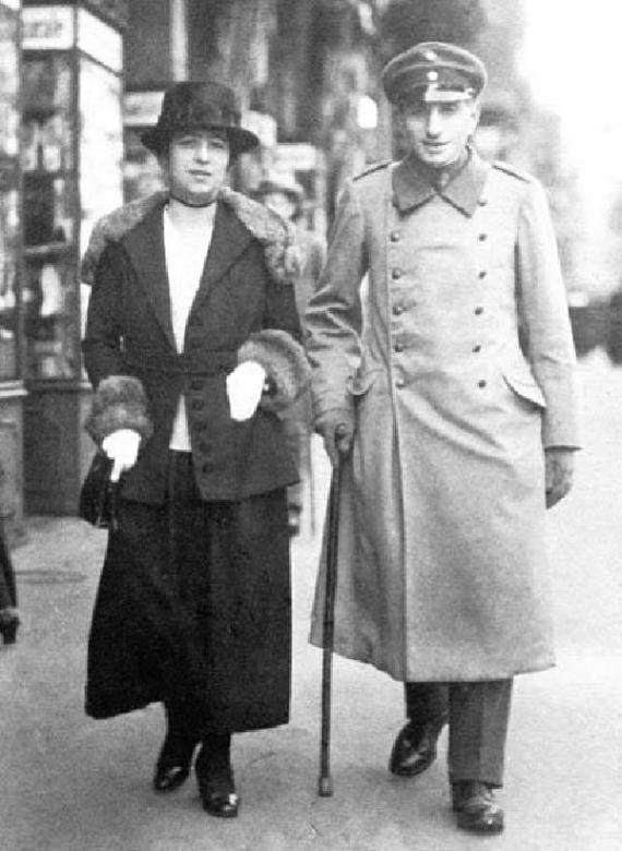 Black and white photograph of a man in uniform and a woman with a fur collar and hat