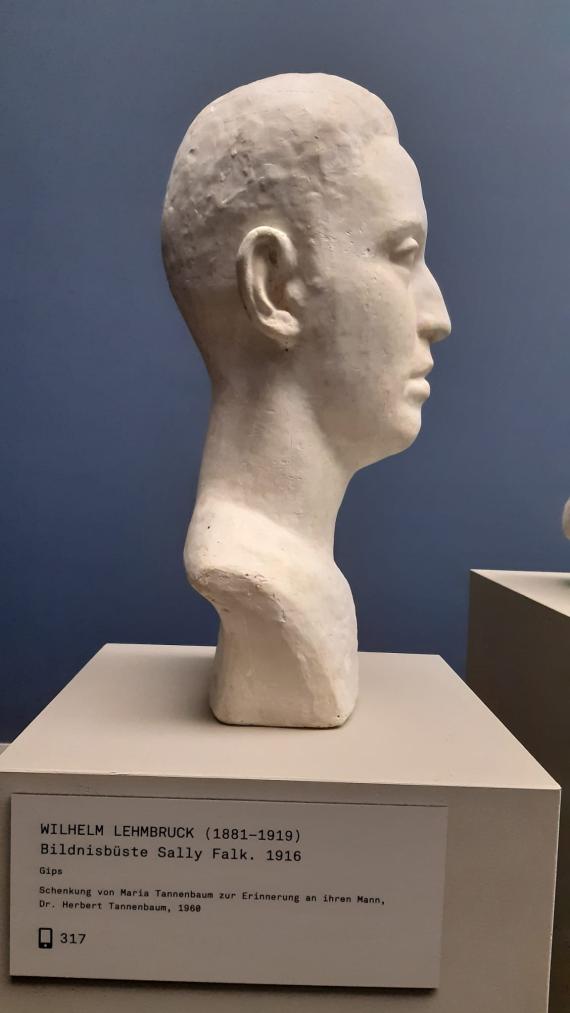 Profile view of a white portrait bust standing on a pedestal