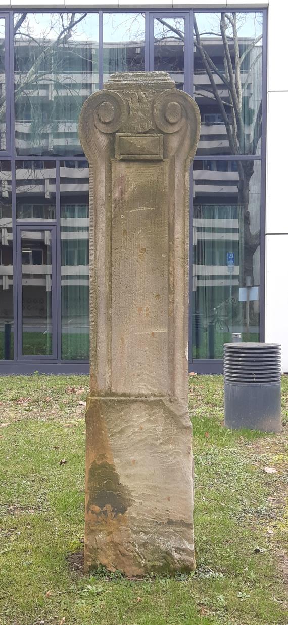 A sandstone pillar on a piece of lawn