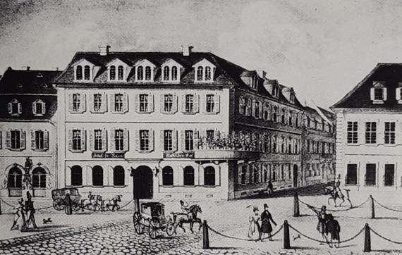 Historical view of a town with buildings and a square with carriages.